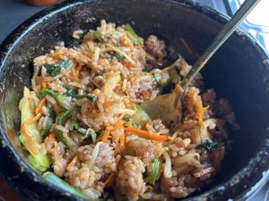 Dolsot bibimbap after adding sauce and stirring. It goes crispy in the smoking hot cast iron bowl    at Cahchi Korean BBQ Restaurant in New Malden