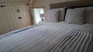 Attic bedroom with kingsize bed and wardrobe at Gorllan in Eglwyswrw