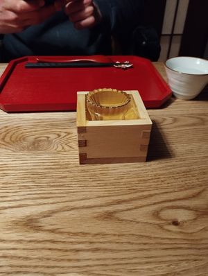 Sake served in a wooden box at UNO RAMEN - Sanjo in Kyoto