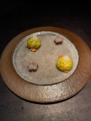 creamy cashew-apple bite on a crunchy bed of almonds and a gummy bear-like bite (flower) of made of spicy raspberry and red bell pepper   at Pramerl & the Wolf in Vienna
