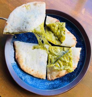 Elevate your meal with unique Moringa Cheese Naan with classic, fluffy dough with nutrient-dense Moringa superfood powder, creating a vibrant green hue and a subtle earthy flavor. at VOG Kyoto in Kyoto