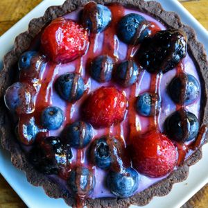 Berry Cream Tart - (vegan & gluten-free) - Venezuelan fair-trade single-origin chocolate & ground almond crust, filled with blueberry / raspberry vegan cream, topped w. fresh fruit at French Meadow Bakery & Cafe in Minneapolis