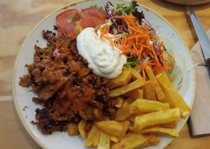 Plato de seitán con patatas y ensalada at Entre Pedras in Santiago De Compostela