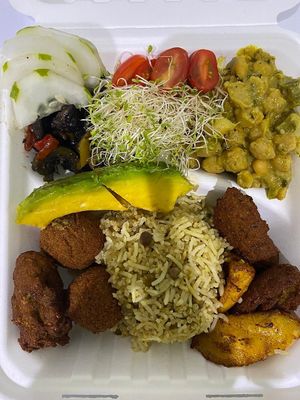 Coco-curry chickpeas served with Basmati Rice & peas, falafels, ripe plantains and fresh salad including local cucumber and sprouts at Empress Ima's Ital Café & Nyce Creamery in Philipsburg
