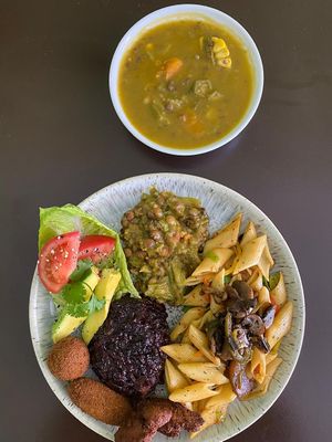 Inness's famous Ital Soup (mild coconut milk, root veggies, dumplings) & Jerk Portobello mushroom served with pasta, stewed lentils, mushroom croquettes and fresh salad at Empress Ima's Ital Café & Nyce Creamery in Philipsburg