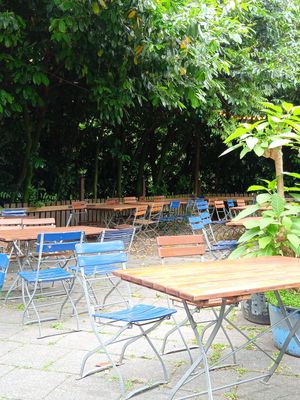 sitting area under the trees at Schwimmbad Rhein-Sommergarten in Cologne