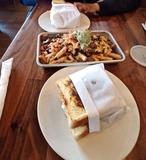 2 Nashville Hot Chicken sandwiches and carne asada loaded fries in middle at Veggie Grill by Next Level in Carlsbad