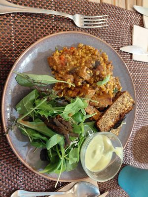 Paella de arroz integral e tempeh, con salsa de avocado e miso blanco, pan de lentejas rojas e rúcula at Luz & Tierra in Malaga