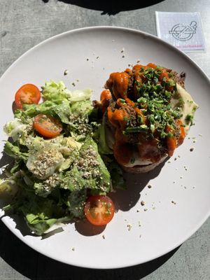 Slice of bread topped with hummus and falafel, with a slide of salad  at Stullenfabrik in Leipzig