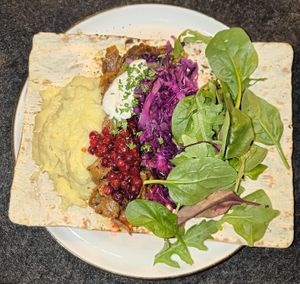 Flatbread, potato puree, lingon berries, pickled cabbage, baby spinach at ÖUR in Stockholm