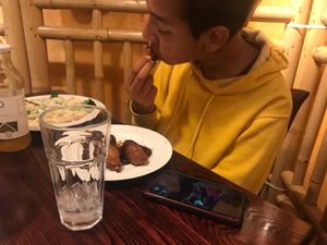bro eating bbq drumsticks and nova pasta at One Veg World in West Covina