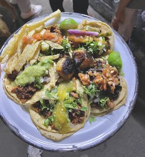 5 al pastor tacos for $65 MXN, loaded up with all the free toppings you can handle: roasted onion bulbs, salsas, fries, black beans, red onion, veggies, you name it  at Por Siempre Vegana - Food Stall in Mexico City