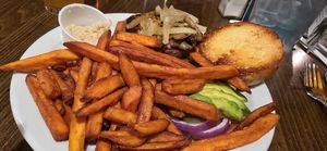 Vegan variation on The Blue Collar, substituted veggie burger, and avocado instead of blue cheese, added horseradish and sweet potato fries. at The Office Bar and Grill in Cheyenne