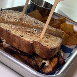 Portobello Sando: Grilled Sandwich Bread, Marinated Portobello Mushrooms, Caramelized Onions, Violife Provolone, Garlic Aioli w/ Seasoned Potatoes at FiKA in Grand Rapids