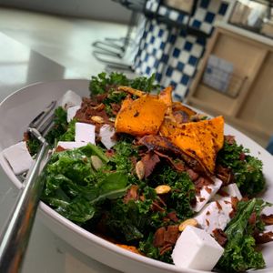 Autumn Squash Salad: Kale, Warm Maple-Roasted Butternut Squash, Violife Feta, Coconut Bacon Bits, Red Onions, Roasted Pepitas & Squash Seeds at FiKA in Grand Rapids