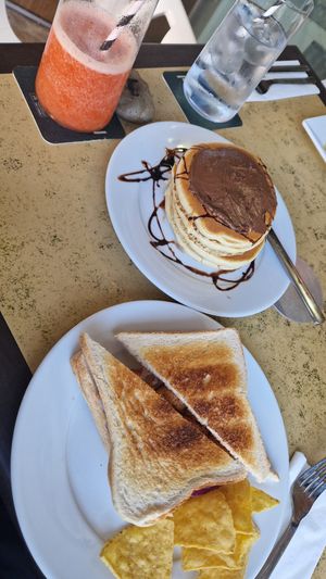 Vegan pancakes w/ maple syrup & chocolate with a sausage & onion toasted sandwich. at Churchill's Kandy's in Mallorca