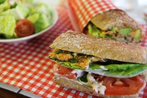 Lentils, Carrot and Herbs Omelette sandwich, with Fresh Avocado (Or Seasonal Roasted Peppers), Tahini, Carrot Spread, Cucumber, Tomato and Lettuce.  Comes with chopped salad - lettuce, tomato, radish, dressing at Cafe Landwer - Ibn Gavirol in Tel Aviv