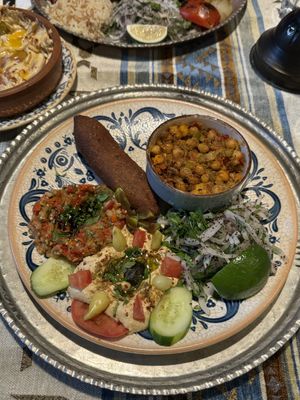 Mixed vegetarian plate (karışık vejeteryan tabak) with içli köfte (stuffed bulgur balls), spiced chickpeas, eggplant meze, and hummus.  at Mozaik Bahce in Fethiye