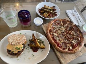 Malibu melt (black bean burger) with potato wedges, extra potato wedges, and a pepperoni pizza. All vegan! Butterfly pea flower tea drink (virgin cocktail) was also delicious  at Seedz Cafe in St Louis