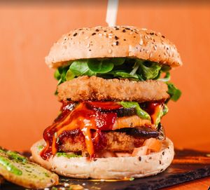 ¡Prueba nuestra espectacular "Hipster"! 🍔 Dos rodajas de pollo vegano, calabaza, calabacín, berenjena al horno, tomate, canónigos y salsas caseras en un delicioso brioche veg at Logan's Garden in Madrid