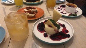 Mocktails and vegan Panna cotta made from creamed nuts, with sweet biscuits and dark berry coulis. It was chef's kiss! 👌🏾😘 at Bar Galería Aura in Concepcion