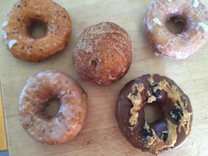 Lemon lavender, Thai tea, churro cream-filled, rose cardamom, and chocolate peanut butter Oreo. at Donut Panic in San Diego