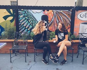 Two customers sitting in the back patio enjoying coffee. at Harold's Coffee Lounge in West Palm Beach