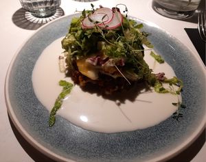 Vegetable-lentil lasagna with white wine sauce and fresh salad with pesto oil at Vegan Restoran V in Tallinn