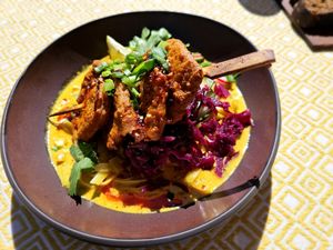 Peanut-orange marinated soy skewers in a slightly spicy curry sauce with rice noodles and red cabbage kimchi at Vegan Restoran V in Tallinn