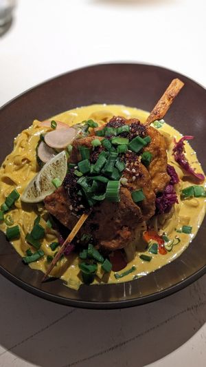 🍢 Peanut-orange marinated soy skewers in a slightly spicy curry sauce with rice noodles and red cabbage kimchi - (15€) at Vegan Restoran V in Tallinn