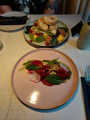 Beetroot ravioli with cashew cream sheese and basil pesto & Classic pâté, feta cream, olive tapenade, nuts, sheese cubes and garlic bread at Vegan Restoran V in Tallinn