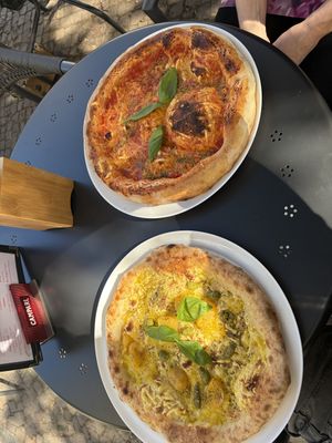 Pizza Margherita (oben) und Pizza Pesto i Pomodoro gialli (unten) auf einem Aussentisch  at volare in Leipzig
