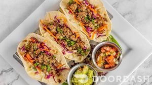 Impossible Tacos, White corn tortilla, cheddar cheese, michoacan slow, ground beef, fresh guacamole, Pico de Gallo, Cilantro. at Vegan Tierra  in North Miami