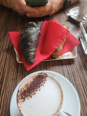 Cappuccino + charcoal croissant and berries croissant at Veganda in Padua