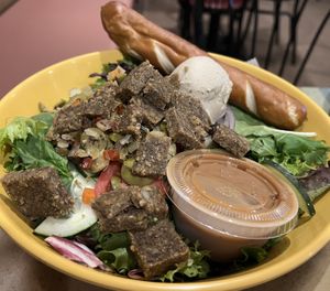 New Day Salad- spring mix topped with raw vegan sausage crumbles, tomatoes, red onion, and a scoop each of cashew cheeze spread and olive salad  at European Street Cafe  in Jacksonville
