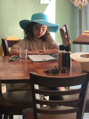 My veg daughter reading their book on healthy diet from their shared collection  at Under the Bodhi Tree in Pahoa