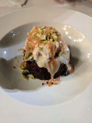 Warm chocolate cake, served with ice cream, hazelnut butter, and pistachio at Anastasia in Tel Aviv