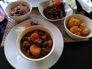 Clockwise: peppered strips, fried dumplings, curry chunks, rice and beans at Fi Real in Bristol