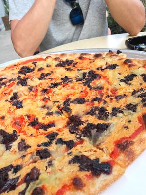 Cashew cheese pizza with pineapples and olives at Hatool HaYarok - The Green Cat in Tel Aviv
