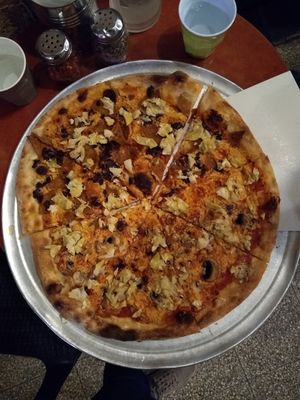 Large pizza with variety of toppings at Hatool HaYarok - The Green Cat in Tel Aviv