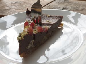 Slice of raw avocado and chocolate tart, garnished with pomegranate seeds at Moehren Milieu Eco Cafe in Mainz