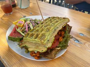 Spinach Waffle sandwich - soy gyros, tomato, avocado cream, and hummus. Includes small salad. at Moehren Milieu Eco Cafe in Mainz