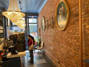 Inside Delice de Bernay. There is a table for inside eating, dedicated to the bakery, plus a table in front at Délice de Bernay in New York City