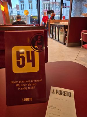 Place order at screen and wait at table at Pureto - Brugge Eiermarkt in Bruges