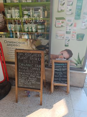 Sign at the street, the deli is in this alleyway at Sacred Garden Plant Based Deli in Rhodes