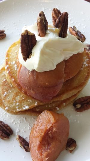 Vegetarian pancakes, short stack, with peach and cream. Vegan option is available.  at True North in Coburg