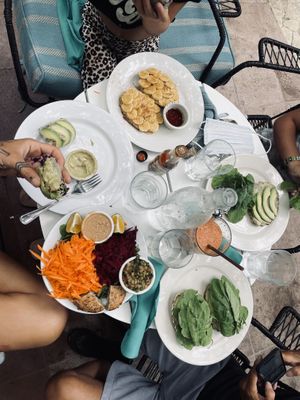 Family breakfast: fresh spring rolls, arugula beet salad w/ added lentils, hummus and pesto sandwich with avo in place of beets, banana nut sandwich, spicy tomato savory smoothie at Juice Bar at the Harmony Hotel in Nosara