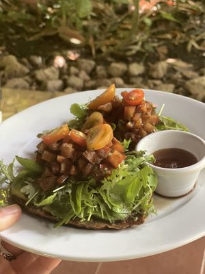 Tomato & Goat Cheese (w/ greens) with avo in place of goat cheese. The tomato medley is like a basaltic rosemary bruschetta on a bed of avo, hummus, & almond based vegan pesto ❤ at Juice Bar at the Harmony Hotel in Nosara