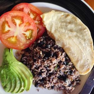 Traditional 'Tico', aka Costa Rican Breakfast: gallo pinto (beans & rice), avocado, tomato, and a homemade corn tortilla.  Breakfast is included in the price of the hotel room and is also served with a fresh fruit plate, juice & coffee.   at Harmony Hotel Restaurant in Nosara