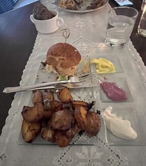 Vegan lentil-based burger, and potato wedges with 3 different types of dipps.   at Moon in Siracusa